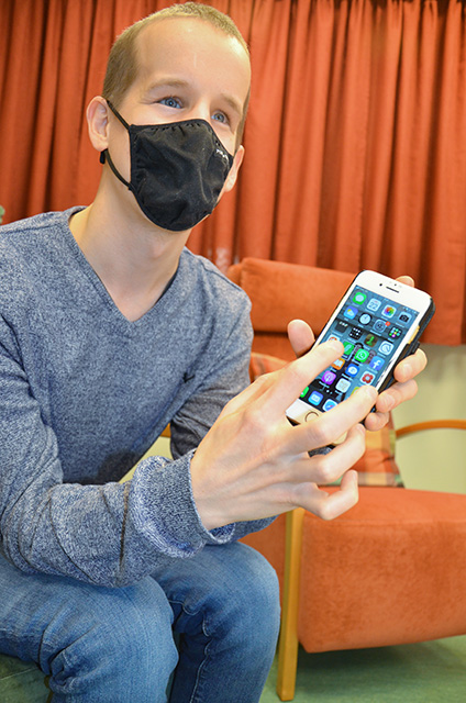 Joona Syri visar hur han använder mobilen.