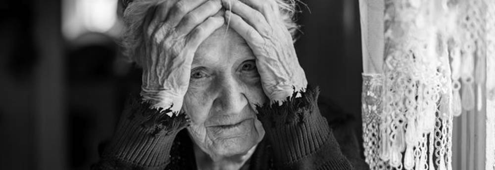 En gammal kvinna som ser bedrövad ut. 