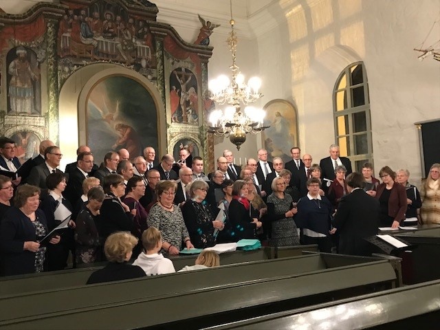 Sångkören uppställd i sockenkyrkan framför altaret.