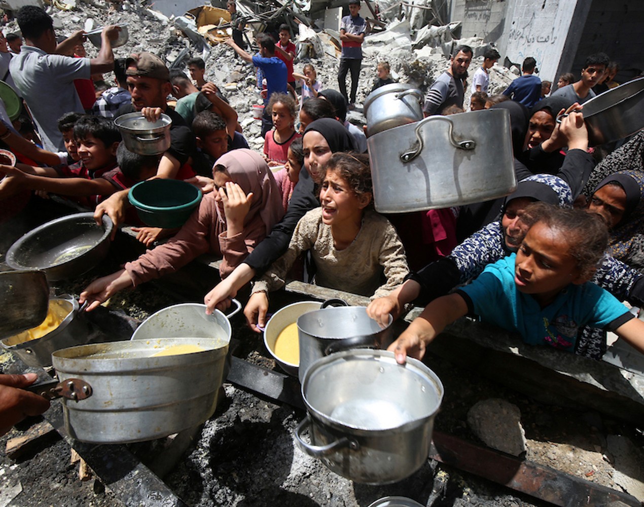 Människor köar med sina kastruller för att få mat i Jabalia i norra Gaza.