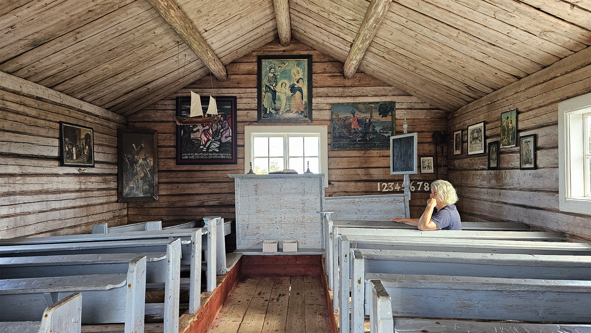 Insidan av Tankar kyrka med altare och de blåmålade bänkarna.